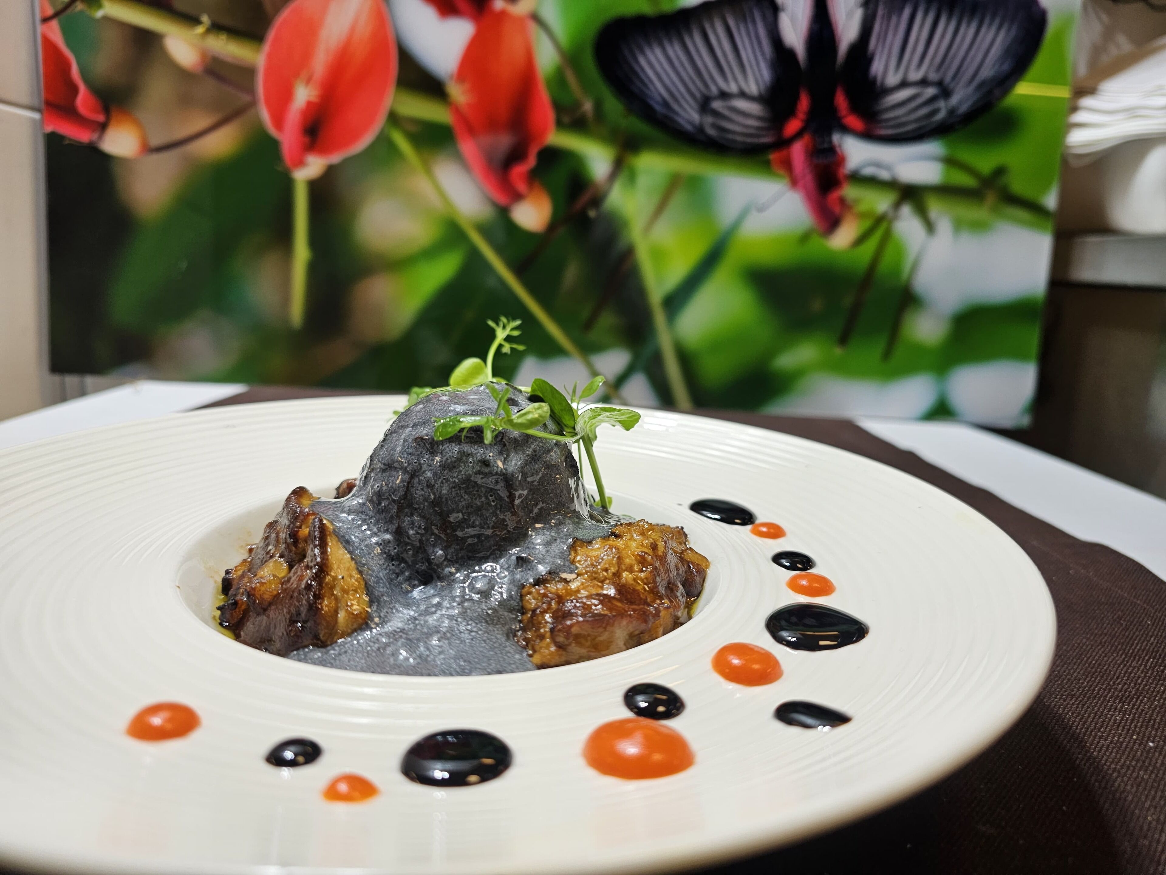 A plate of food with a decorative centerpiece, surrounded by black and orange dots.