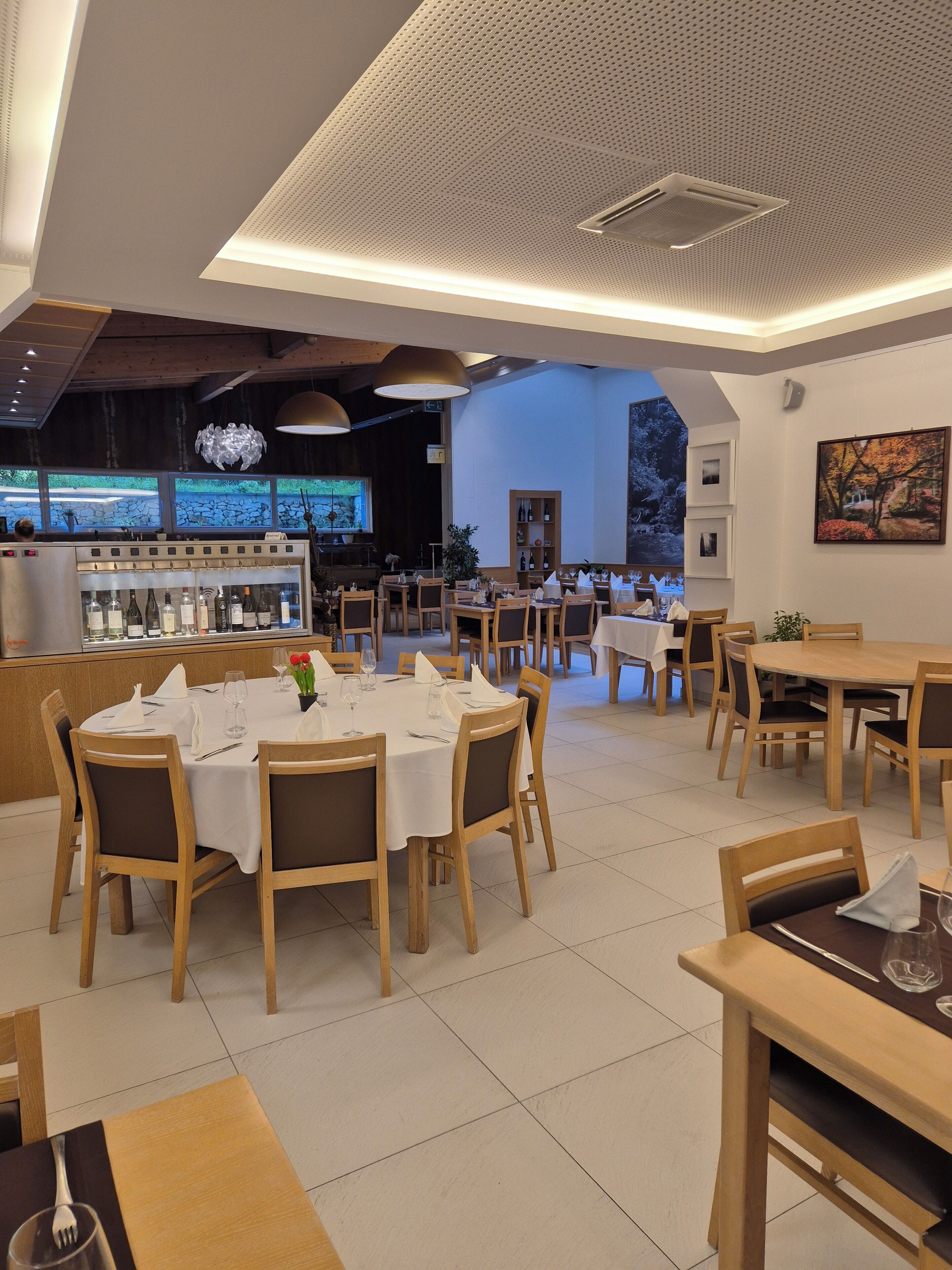 Ein Restaurant mit mehreren Tischen, Stühlen und einer Bar.