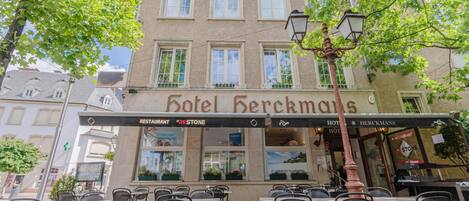 A hotel with outdoor seating and a sign that reads 'Hotel Berckmans.'
