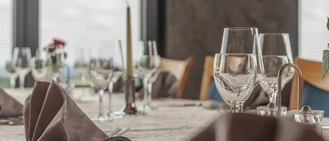 A table set for dining with clear glassware, a folded napkin, and a candle.