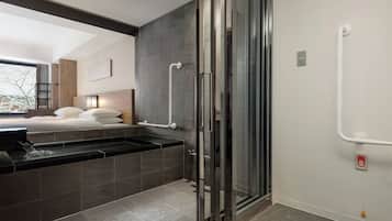 A modern bathroom with a glass shower enclosure, a bathtub, and a toilet.