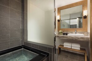 A modern bathroom with a large mirror, a built-in sink, a vanity, and a bathtub. - Courtyard by Marriott Hakuba (Hakuba)