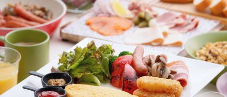 A breakfast spread with various foods including eggs, bacon, mushrooms, and vegetables.