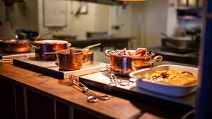 Un plan de travail de cuisine avec des casseroles, des poêles et un plat à four.