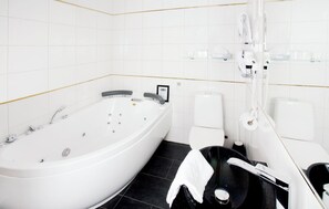 A modern bathroom with a freestanding bathtub, a toilet, and a bidet. - Tällbergsgårdens Hotell (Tallberg)