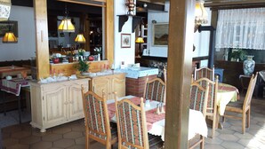 A cozy dining area with wooden furniture and a tiled floor. - Hotel Waldeck (Todtmoos)