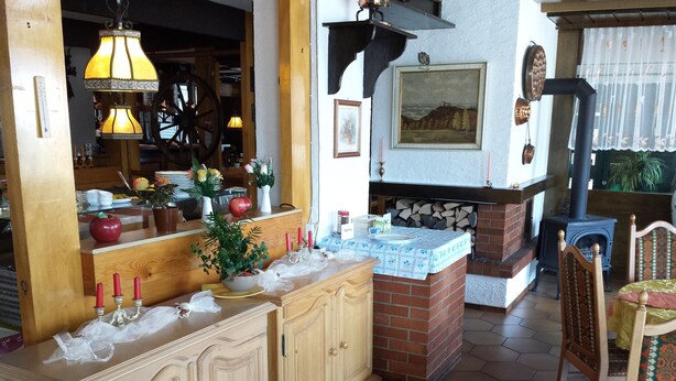 A cozy kitchen with wooden cabinets, a brick fireplace, and a stove. - Hotel Waldeck (Todtmoos)