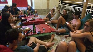 A group of people sitting on a tiled floor around a small table with drinks and snacks. - Le Petit Gili (Gili Trawangan)
