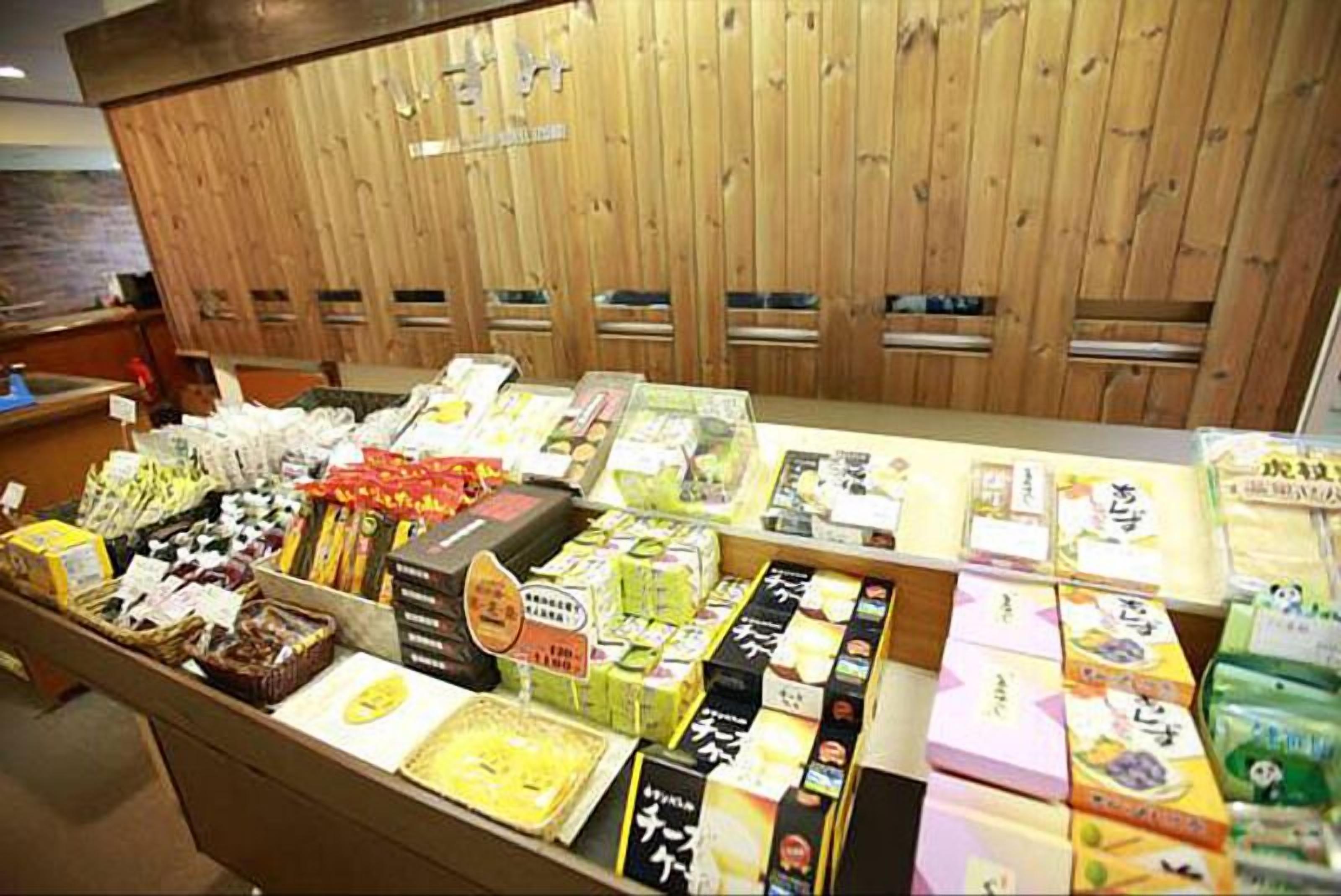 A variety of packaged goods displayed on a counter with wooden paneling in the background.