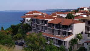 A coastal residential area with multi-story buildings, balconies, and a view of the sea.