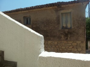 A rustic building with a stone foundation and a tiled roof.