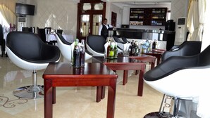 A hotel lobby with modern furniture, a bar area, and a television.