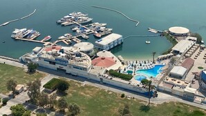An aerial view of a cruise ship docked at a marina with a swimming pool and a large building nearby. - C Hotel (Manama)