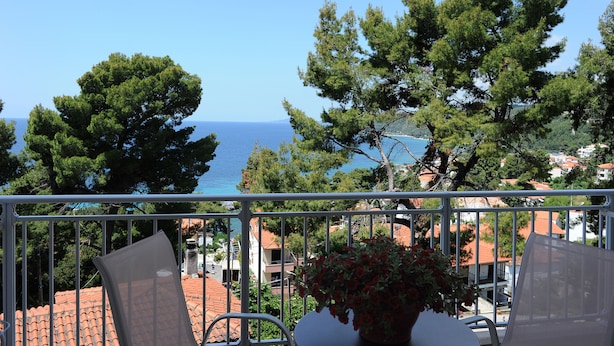 A balcony with a view of the sea, surrounded by trees and buildings. - Rodon Loutra (Kassandra)