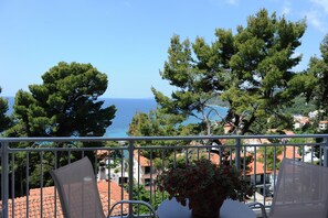 A balcony with a view of the sea, surrounded by trees and buildings. - Rodon Loutra (Kassandra)