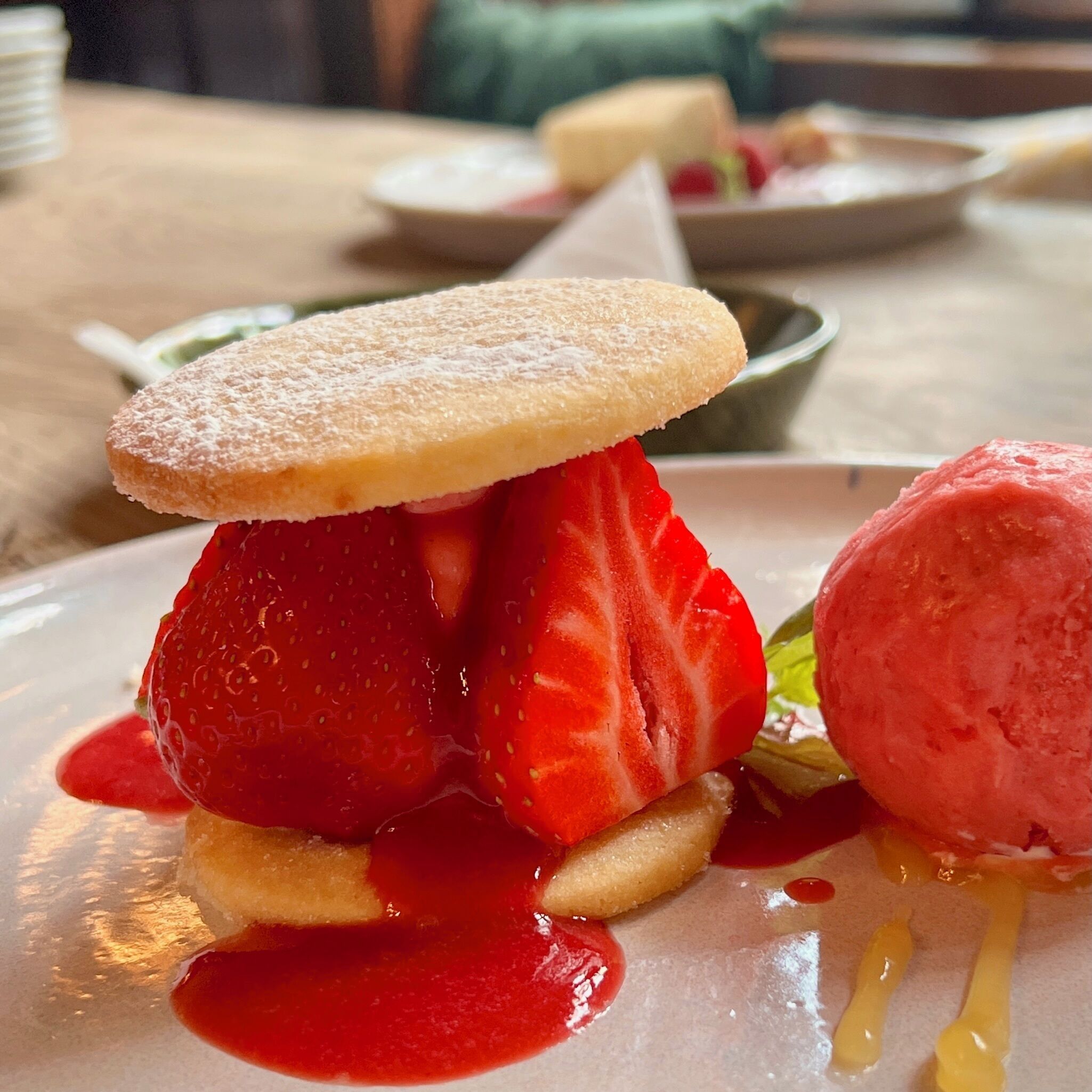 Ein Dessertteller mit Erdbeere und einer Kugel Eis.