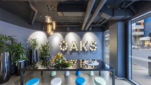 A modern bar area with a sign reading "OAKS" and a view of the street outside. - Oaks Melbourne Southbank Suites (Southbank)