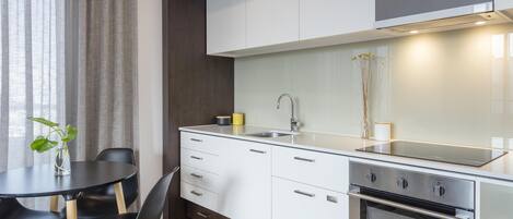 Una cocina moderna con comedor, que incluye una mesa redonda, sillas y un horno empotrado.