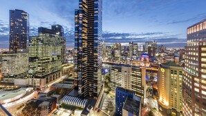 Un immeuble de grande hauteur doté d’une façade moderne en verre, entouré d’autres bâtiments imposants au cœur d’un paysage urbain.