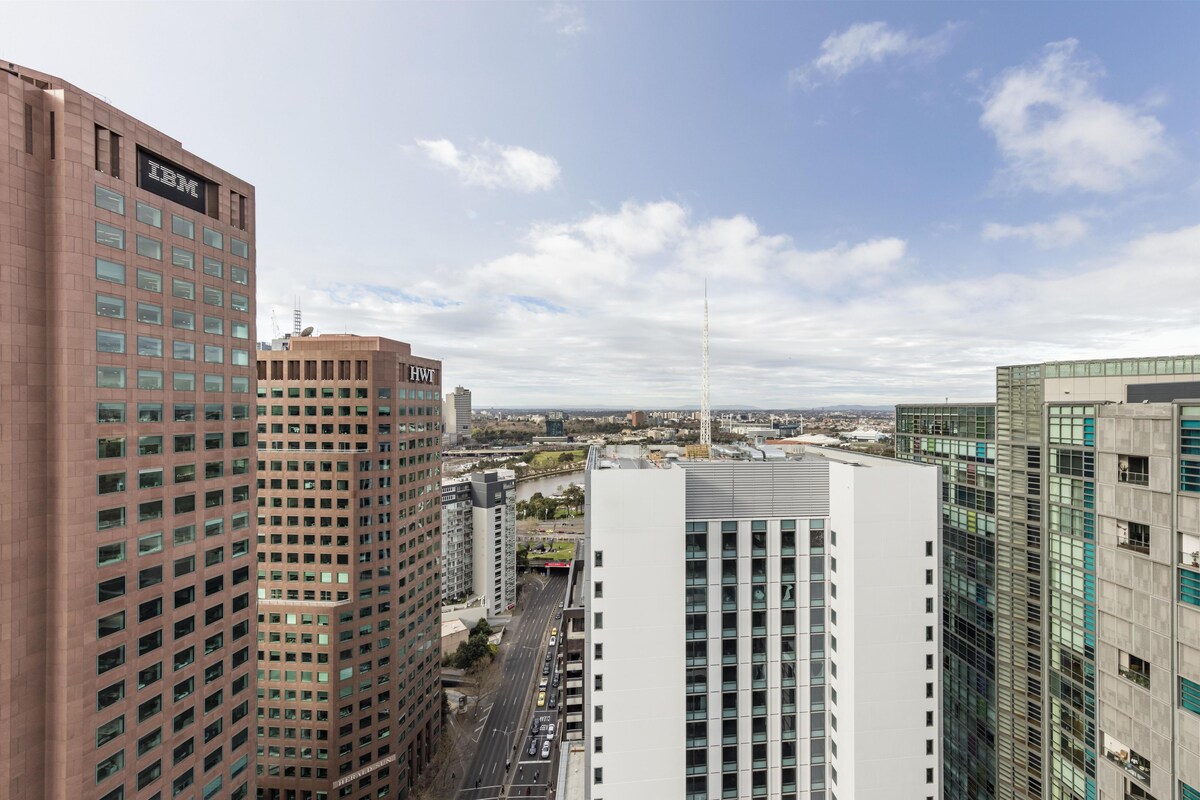 Un immeuble de grande hauteur, sur lequel on peut voir un grand panneau IBM, entouré d’autres bâtiments modernes et sous un ciel dégagé.