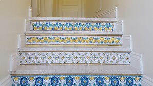 Eine Treppe mit weißen Stufen und Fliesen in Blau und Gelb.