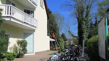 Ein Hotel mit Balkon, Fahrrädern vor der Tür und einer Flagge.