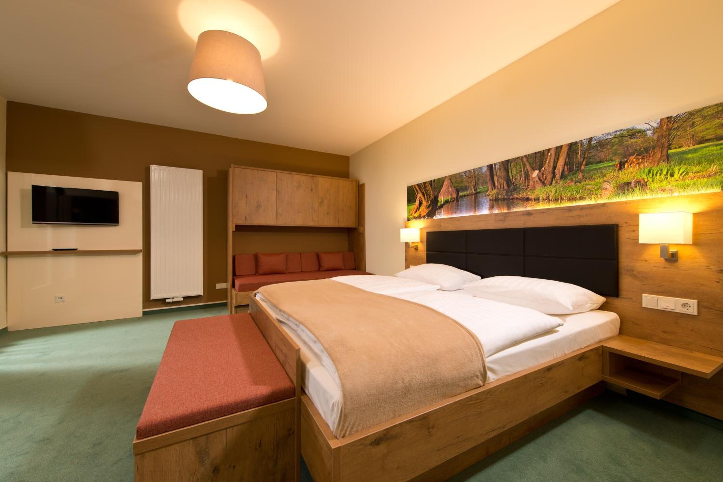 Un dormitorio moderno con una cama de madera, un banco, un televisor y un cuadro.