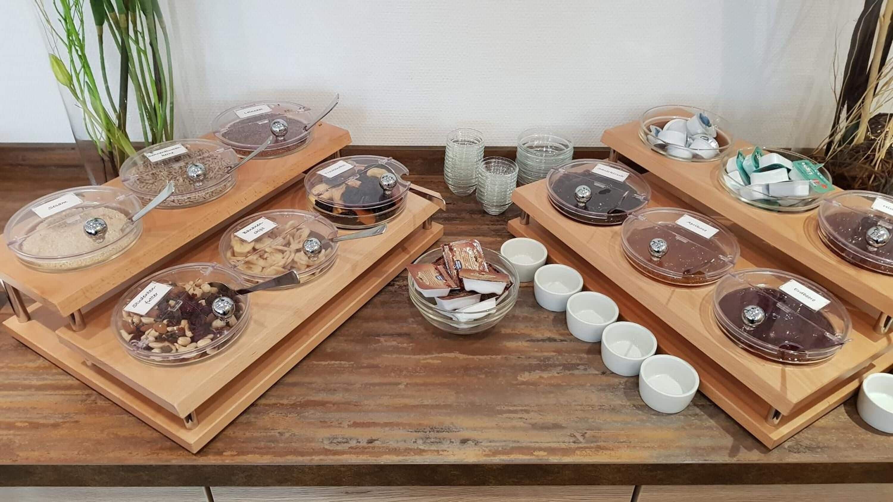 Ein Buffet mit verschiedenen Speisen und Beilagen auf Holztischen.