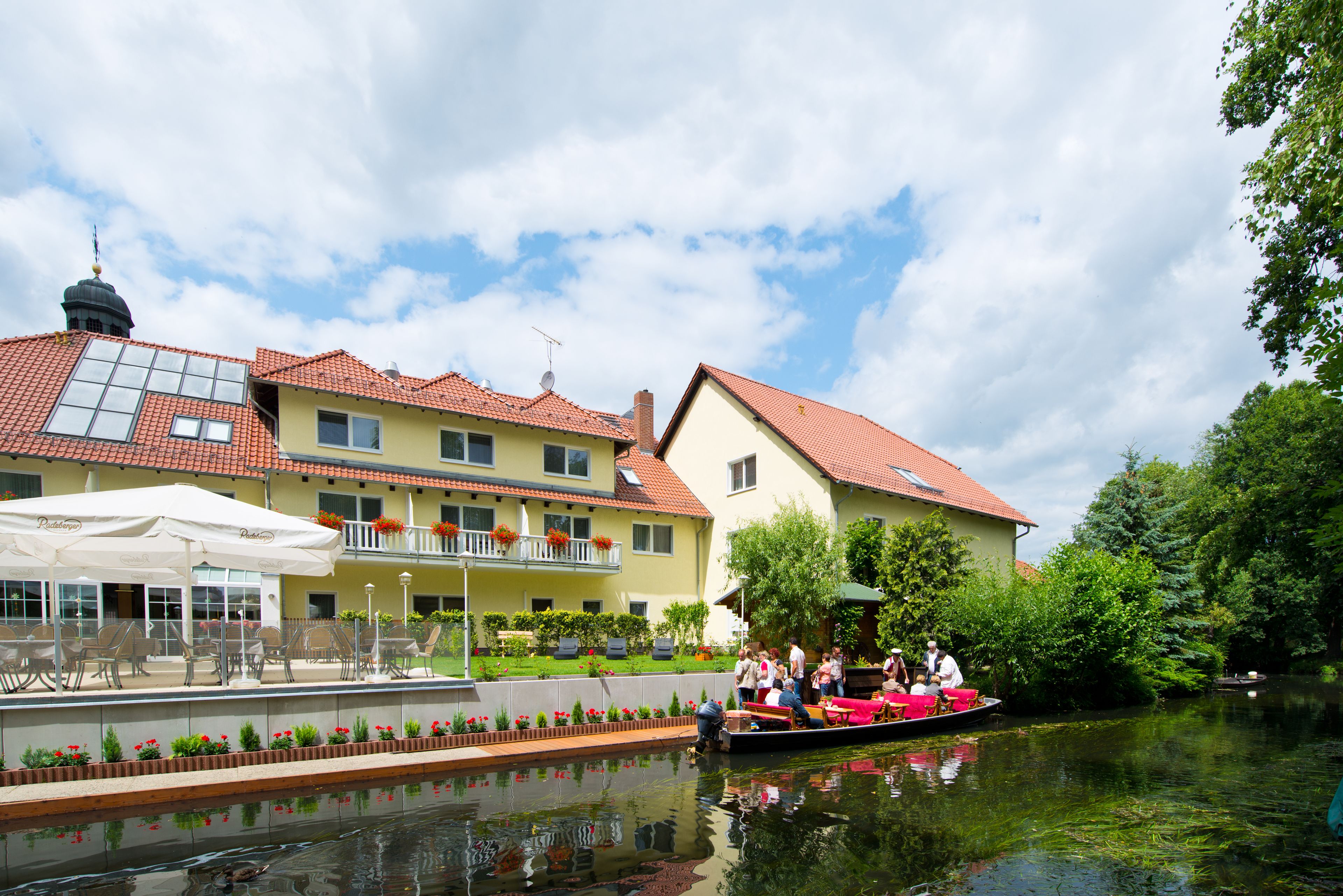 A riverside hotel with outdoor seating and a boat dock.