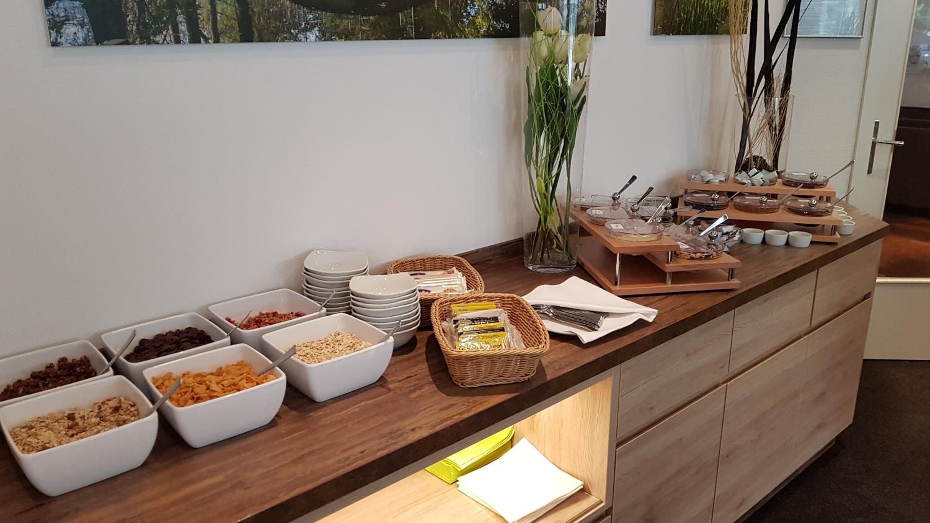 A buffet counter with various food items and utensils.