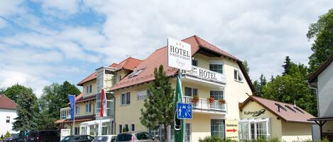 A hotel with a sign indicating "HOTEL & RESTAURANT" and a directional sign pointing to "Kahnstub".
