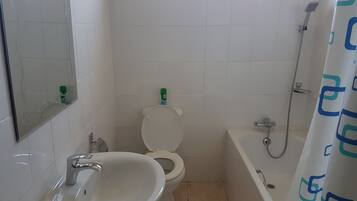 A bathroom with a sink, toilet, and bathtub.