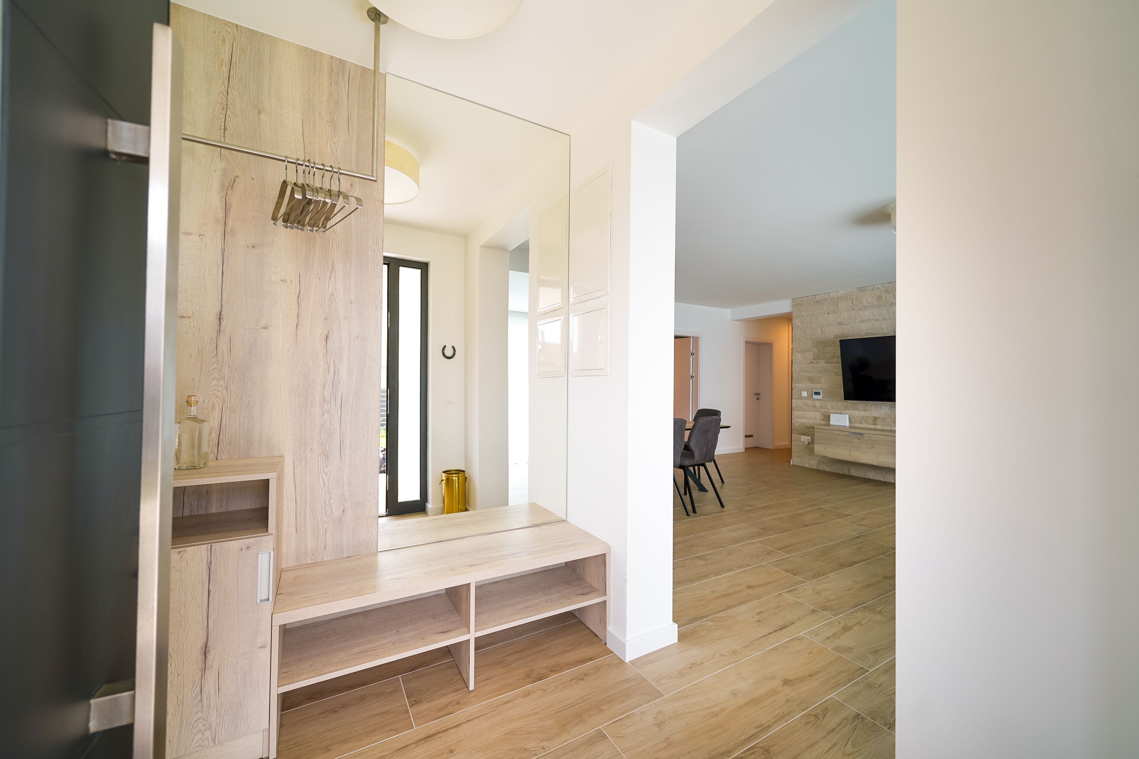 Un salon moderne avec un banc en bois, un téléviseur et une cheminée.