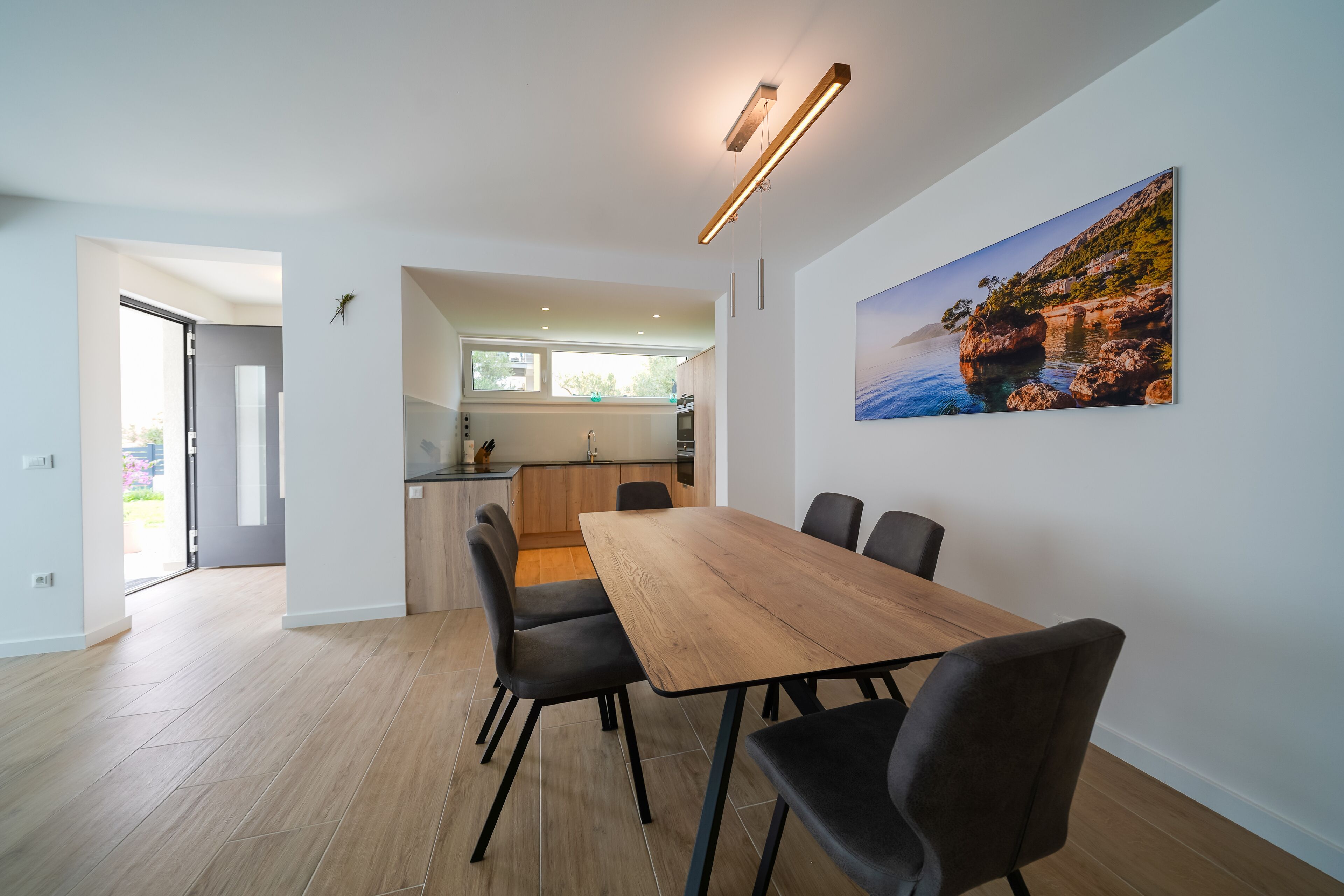 Una cocina moderna con encimera de madera y un comedor con mesa y sillas de madera.