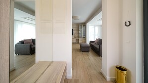 Un salon moderne avec un plancher en bois, un canapé gris et une petite table.