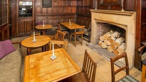A cozy pub interior with wooden furniture, a fireplace, and a menu board. - The Cardinals Hat (Worcester)