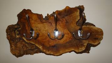 A wooden surface with three metal hooks.
