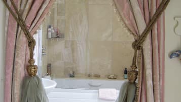 A bathroom with a bathtub, a sink, and a mirror.