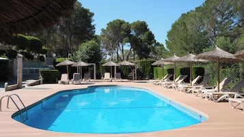 Una piscina al aire libre, sombrillas, tumbonas