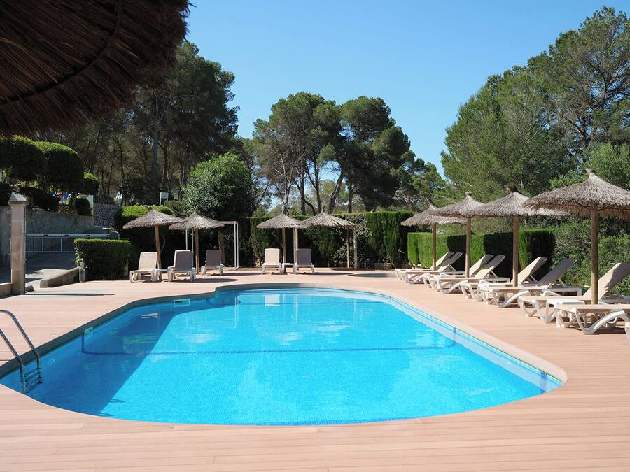 Una piscina al aire libre, sombrillas, tumbonas