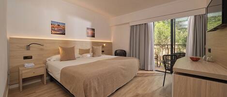Una habitación de hotel moderna con una cama grande, un escritorio, una silla y un televisor.