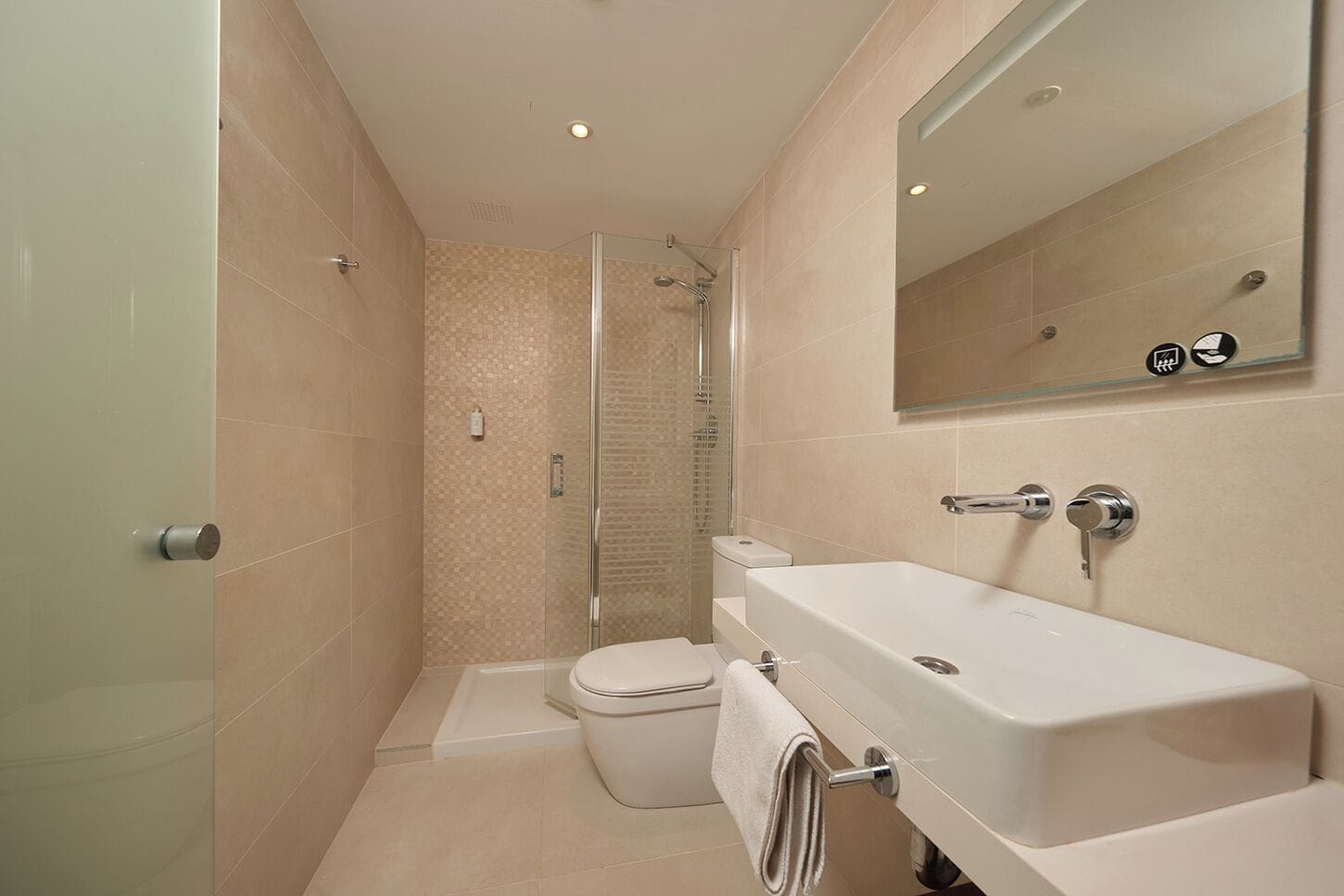 A modern bathroom with a shower, toilet, and sink.