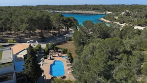 Um resort com piscina, espreguiçadeiras e vista para o mar.