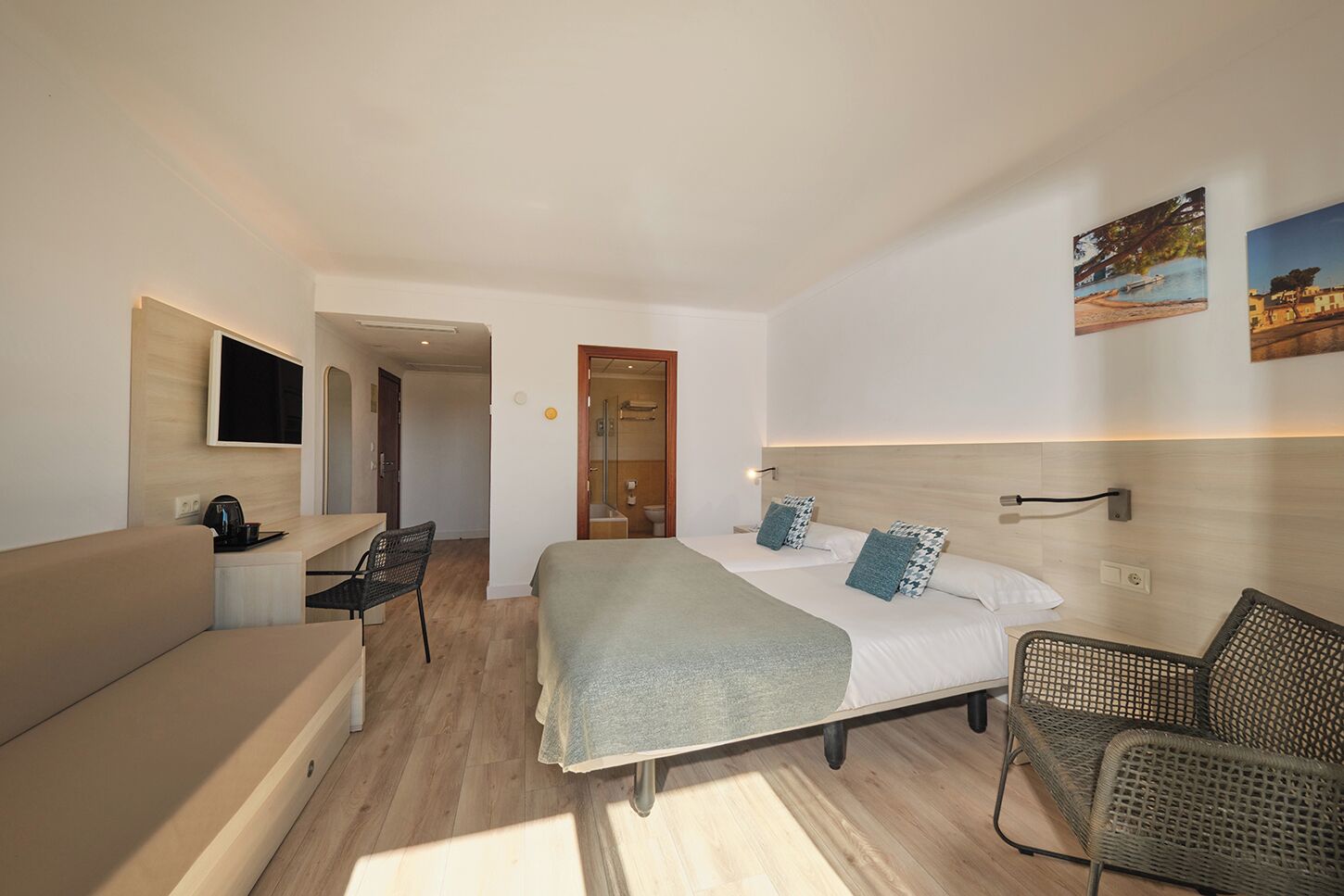 Een hotelkamer met een bed, een bureau, een stoel en een televisie.