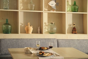 A dining area with a table set for two, featuring a plate of food and two glasses of wine. - Hotel Playa Mondrago (Santanyi)