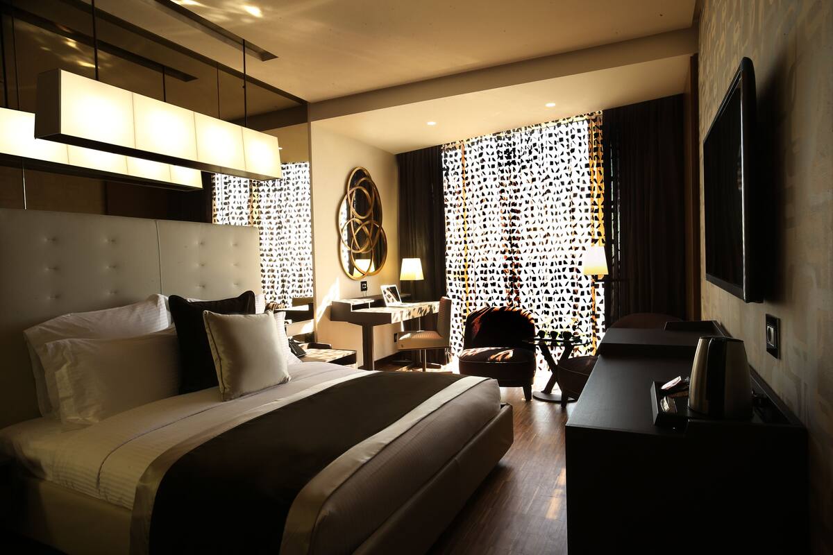 Une chambre d’hôtel avec un grand lit, un bureau, une chaise et un téléviseur.