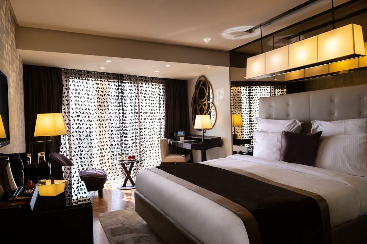 Une chambre d’hôtel moderne dotée d’un grand lit, d’un bureau et d’un coin salon.