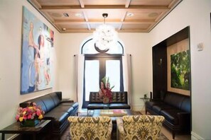 A hotel lobby with a seating area, a chandelier, and artwork on the walls. - HGU New York Hotel (New York)
