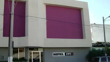 En hotels bygning med et stort skilt, der viser 'HOTEL ITT', og en tydelig indgang med en glasdør.