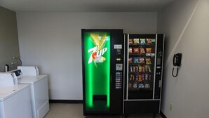 Ein Zimmer mit einem 7UP-Automaten, einem Telefon und einer Waschgelegenheit.
